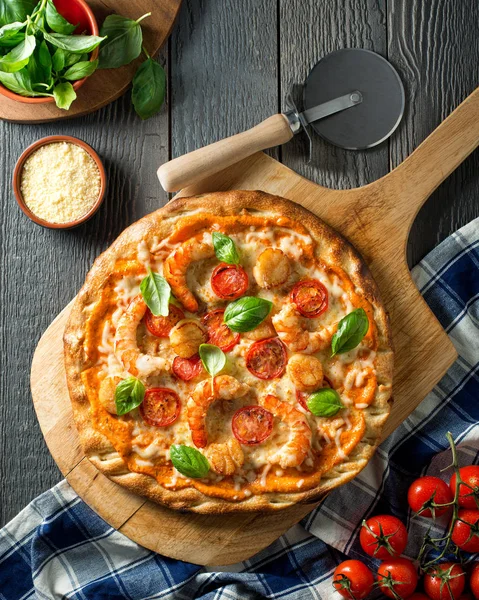 Meeresfrüchte-Pizza mit Garnelen, Jakobsmuscheln, Tomaten und Basilikum mit würziger Paprika-Sauce. — Stockfoto