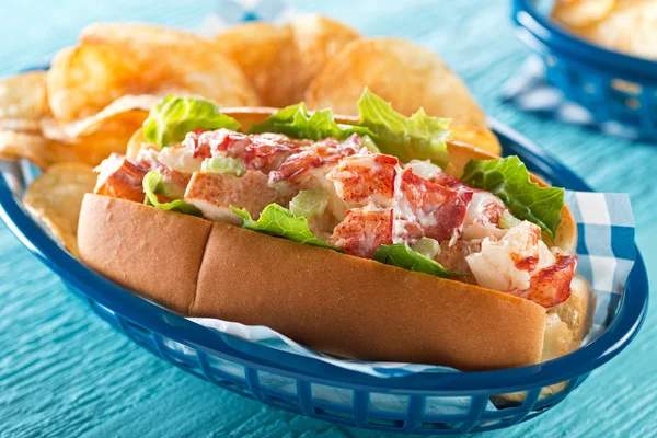 A delicious lobster roll with lettuce, celery, mayonnaise, and potato chips. — Stock Photo, Image