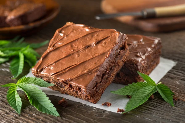 Delicious homemade pot brownies with marijuana leaf garnish. — Stock Photo, Image