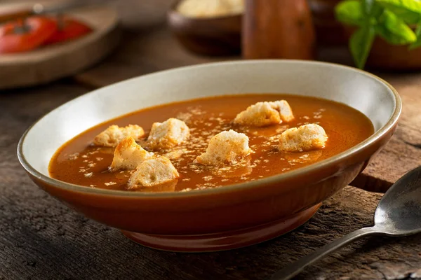 Un delicioso tazón de sopa casera de tomate rústico con croutons y queso parmesano . —  Fotos de Stock