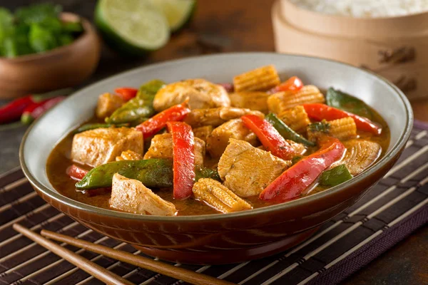 Heerlijke zelfgemaakte Thaise rode curry met kip, rode paprika, peultjes, baby maïs, kokosmelk en koriander. — Stockfoto