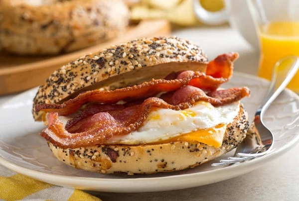 A delicious breakfast bagel with bacon, egg and cheese. — Stock Photo, Image