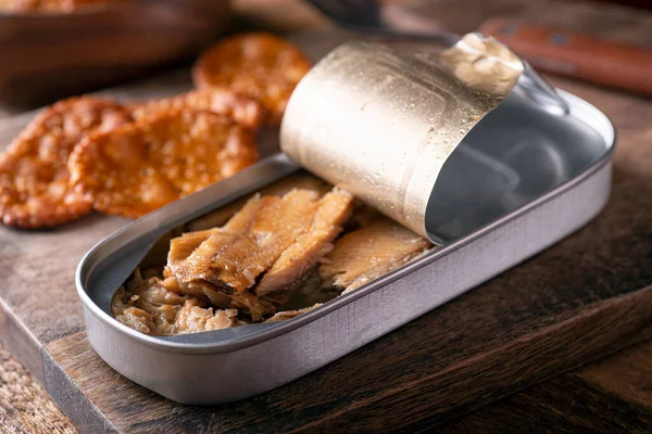 在乡村木桌顶上的一罐熏烟熏鱼和饼干 — 图库照片