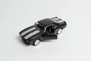 Kaputunda kırmızı çizgiler olan açık kapılı siyah oyuncak araba.