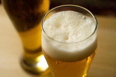 Siyah zemin üzerine bira dökülen kadehlerin yakın çekimi