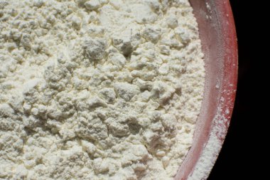 Sağlıklı organik vejetaryen hammaddeler. Siyah arka planda kırmızı tabakta buğday unu. Ev yapımı pişirme. Kapat..