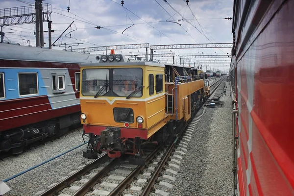 Locomotive on railway tracks between passenger trains — Stock Photo, Image