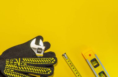 Sarı arkaplanda usta inşaatçı ve aksesuarlar için araçlar