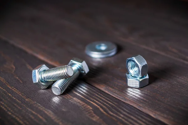 Metal nuts and bolts on black vintage background close up — Stock Photo, Image