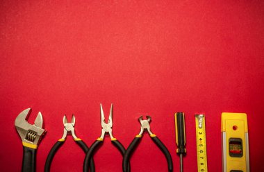 Kırmızı arkaplanda ana inşaatçı için araçlar