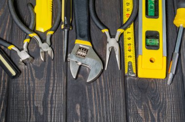 Tools for master builder on a wooden black vintage background