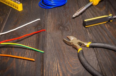 Koyu renk tahta tahtaların onarımından önce elektrikçi için gerekli teçhizat ve kablo