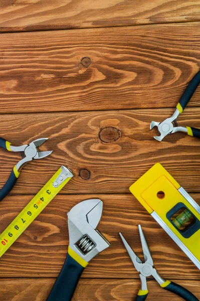 Attrezzi per capomastro preparati prima di lavorare su tavole di legno marroni — Foto Stock