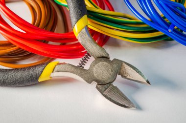 Elektrikçi için pense aracı ve kablolar gri arkaplana yakın plan