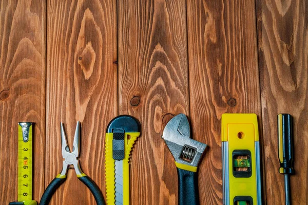 Attrezzi per capomastro preparati prima di lavorare su tavole di legno marroni — Foto Stock