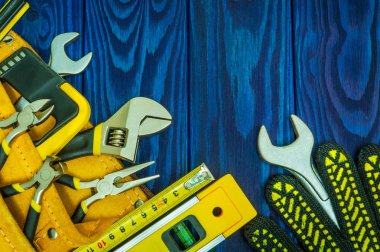 Mavi ahşap tahtalar üzerinde çalışmadan önce usta inşaatçılar için hazırlanan çantadaki aletler.