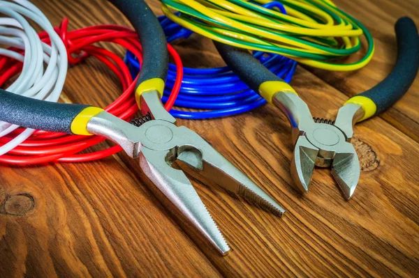 Tænger værktøj og ledninger til elektriker closeup på træplader - Stock-foto