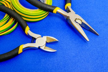 Elektrikçi için pense aracı ve kablolar mavi arkaplanda yakın plan