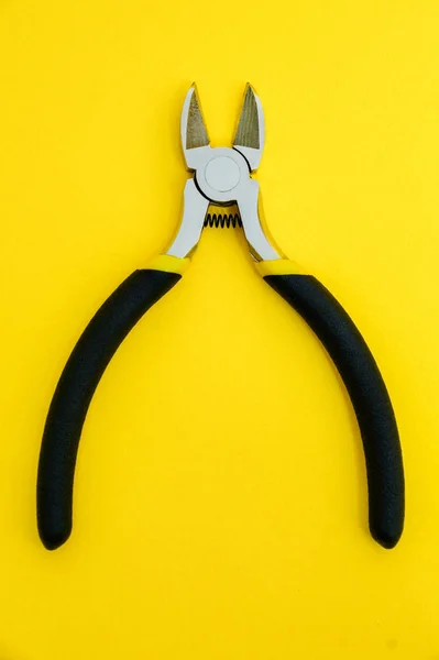 黄色の背景にマスター電気技師のためのゴムハンドル付きシングルプライヤツール — ストック写真