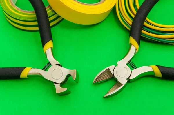 Pliers szerszám és vezetékek villanyszerelő közelkép zöld háttér — Stock Fotó