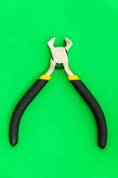 緑の背景にマスター電気技師のためのゴムハンドル付きシングルペンチツール — ストック写真