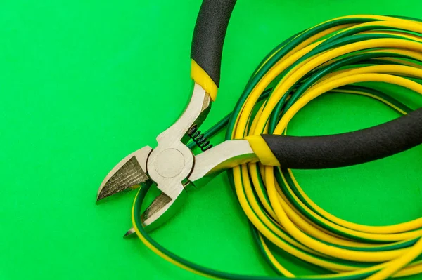 Szczypce narzędzie i przewody do elektryka zbliżenie na zielonym tle — Zdjęcie stockowe