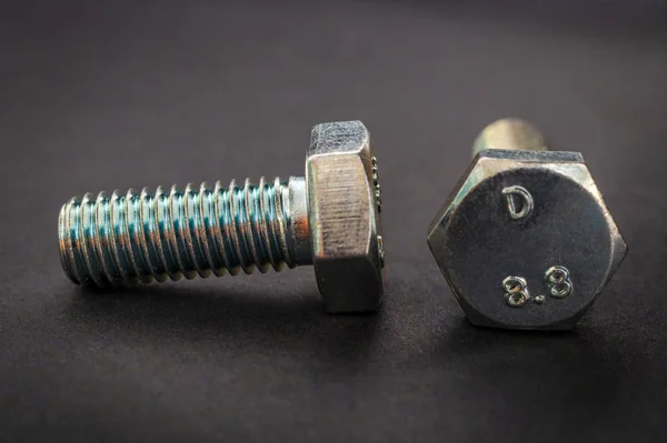 Two metal bolts on black background are used in construction — Stock Photo, Image