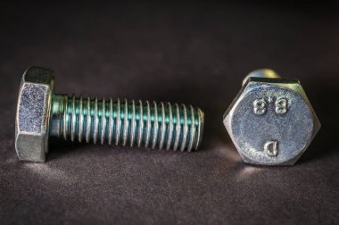 İnşaatta siyah arkaplanda iki metal cıvata kullanılıyor