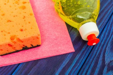 Mavi ahşap tahtaları temizlemek için ped ve havlu ile sıvı deterjan.