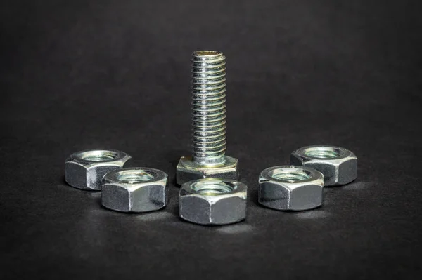 Metal bolt and nuts on black background are used in construction