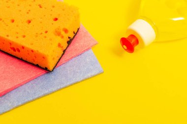 Sarı arka planda hasat için ped ve havlu içeren sıvı deterjan.