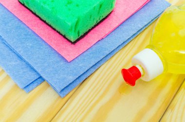 Tahta tahtalarda hasat etmek için farklı renkte havlu ve ped içeren sıvı deterjan.