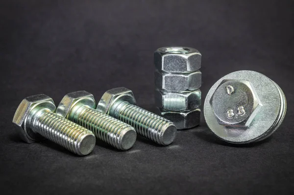 Metal bolts and nuts on black background are used in construction — Stock Photo, Image