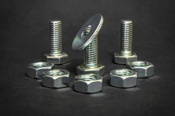 Metal bolts and nuts on black background are used in construction — Stock Photo, Image