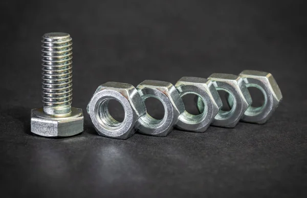 Metal bolt and nuts on black background are used in construction — Stock Photo, Image