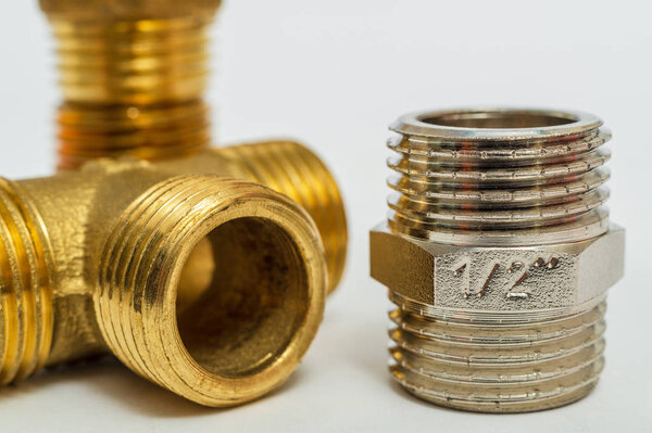 Set of brass fittings is often used for water and gas installations on gray background