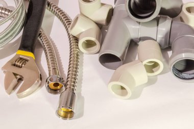 Gri arka planda tesisat tamiri için yedek parça ve aksesuarlar.