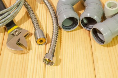 Ahşap bir arka planda tesisat tamiri için yedek parça ve aksesuarlar.