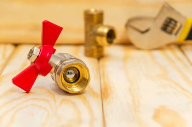 Tahtada kırmızı saplı su vanası var.