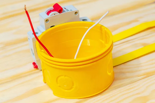 Skrzynka przyłączeniowa żółta z przewodem kablowym stosowanym w procesie instalacji elektrycznej — Zdjęcie stockowe