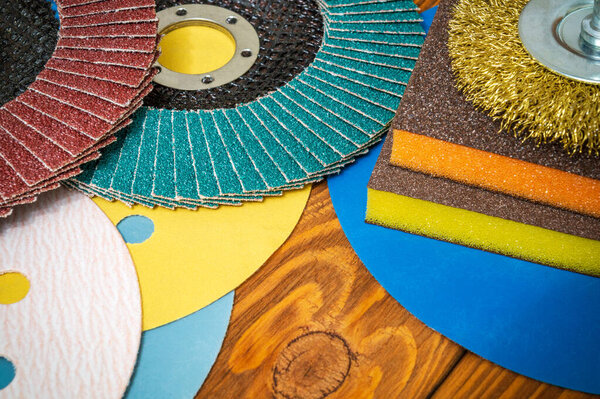 Set of abrasive tools and sandpaper on vintage wooden background