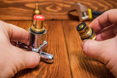 Çarmıha gerilmiş sıcak ve soğuk su. Yedek parçaların ana şalteri elinde. Tesisatçı usta.