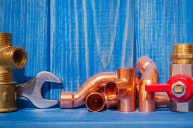 Mavi eski ahşap tahtalardaki tesisat tamiri için yedek parça ve aksesuarlar.