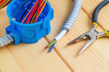 Evde elektrik tamiratı için kablo ve araçlarla dolu bir bağlantı kutusu.