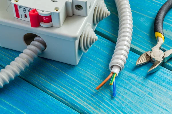 Caja de conexiones con cable y herramientas para la reparación de la electricidad en casa — Foto de Stock