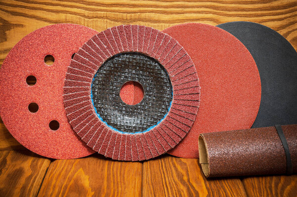 Set of abrasive tools and sandpaper on vintage wooden background. The wizard is used for grinding items