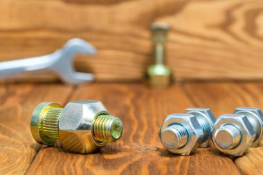 Yeni metal somunlar ve cıvatalar ahşap eski tahtalarda kapanıyor.