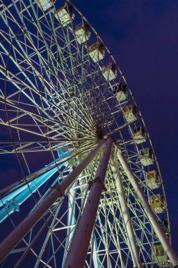 Gece geç saatlerde parktaki dönme dolapta parlayan ışıklar vardı.