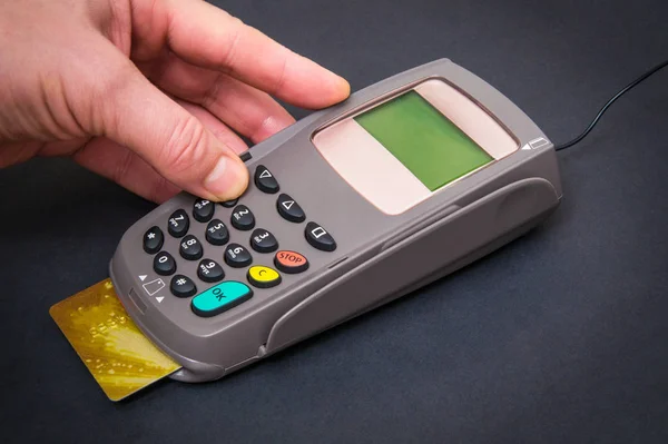 Hand entering pin code to money terminal before payment