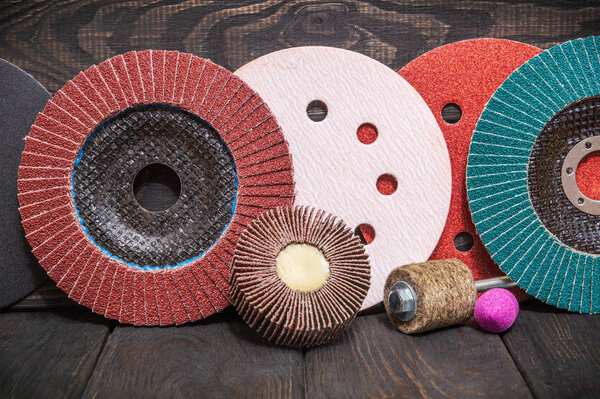 Big set of abrasive tools and multicolored sandpaper on wooden vintage black background